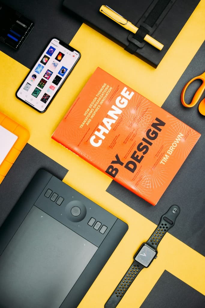Change by Design book with creative design tools on a yellow and black background